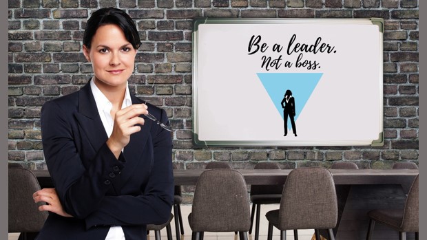 A business woman with a whiteboard that reads 'Be a leader, not a boss'