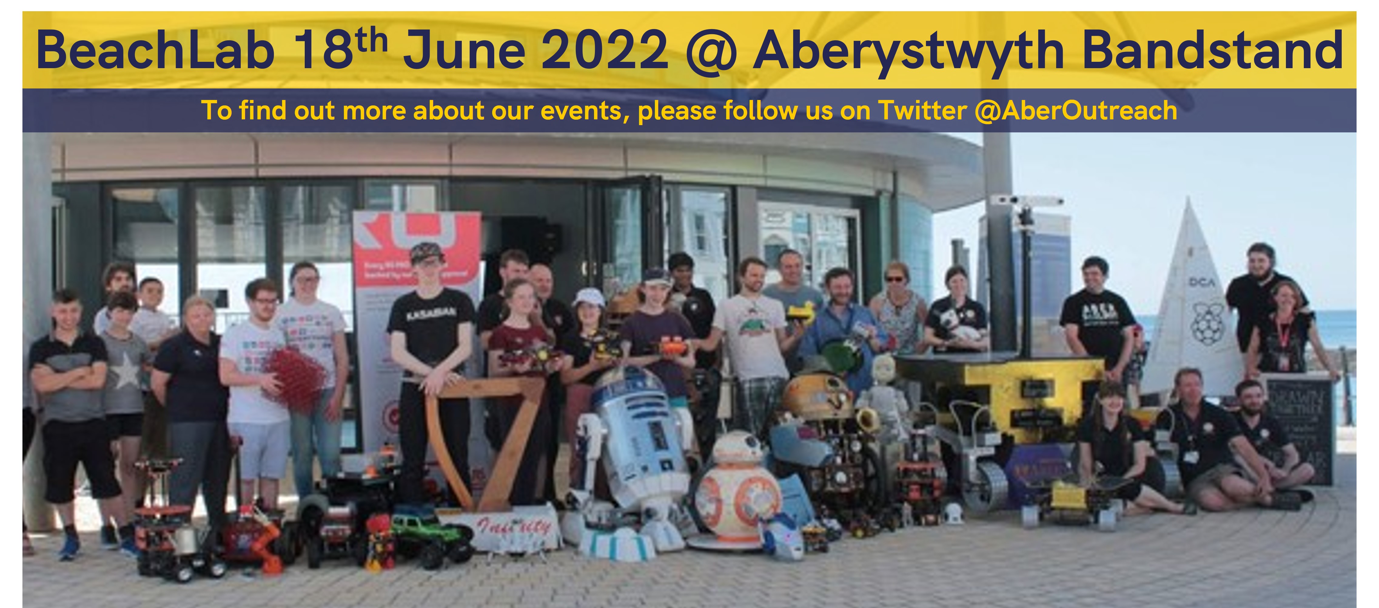 An photograph of all those involved in BeachLab 2019 outside Aberystwyth Bandstand. Banner present advertising BeachLab on 18th June 2022 at Aberystwyth Bandstand. Also includes a reminder of our Twitter account @AberOutreach to find out more about our events.