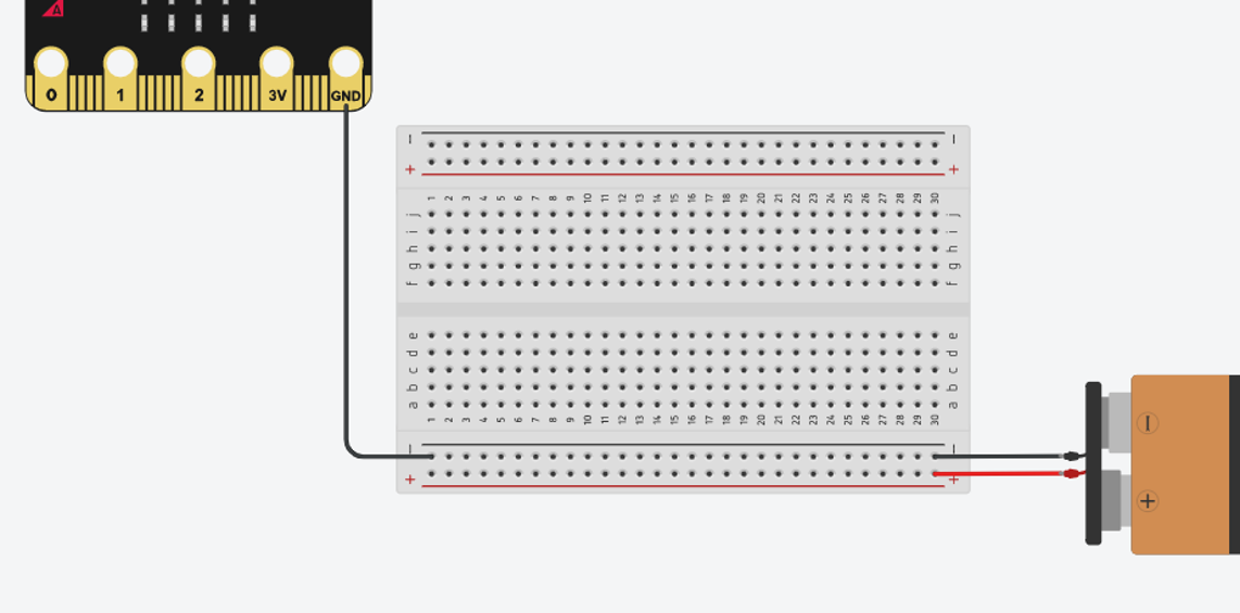 A breadboard with the negative rail connected to both the GND pin on the Micro:Bit and the negative terminal of a 9V battery. The positive rail is only connected to the positive terminal of the 9v battery.