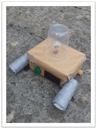 A shoe-box rover for carrying tools. Has a lightbulb in a clear plastic dome on top.