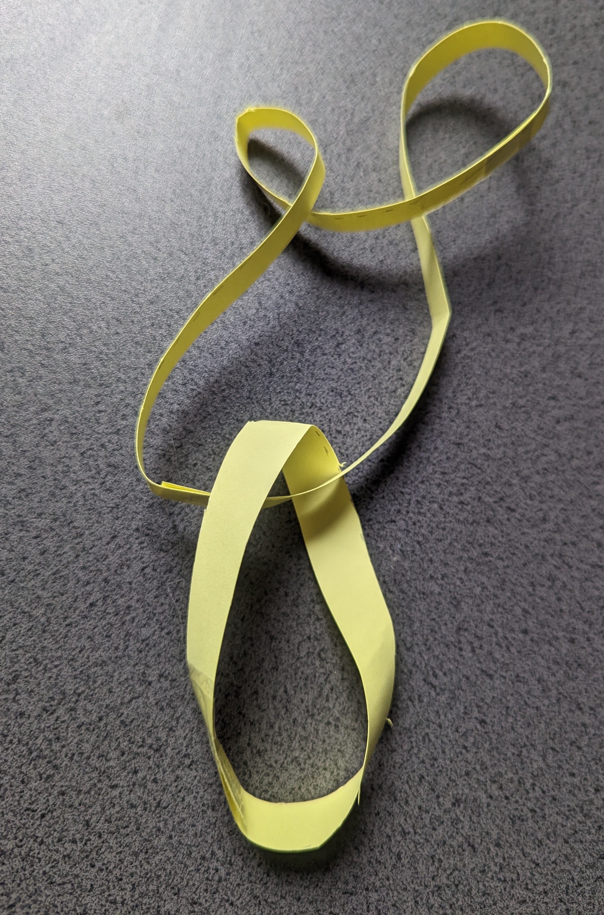 A Möbius Strip interlocked with a loop containing four twists.