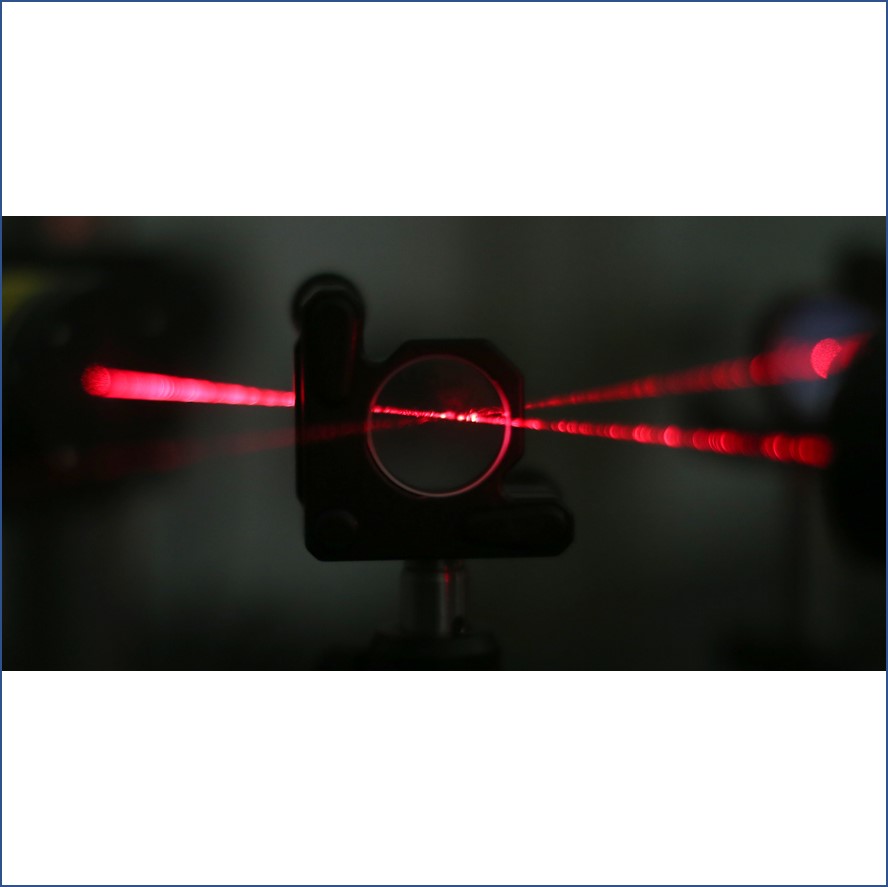 a red laser beam being split through a lens