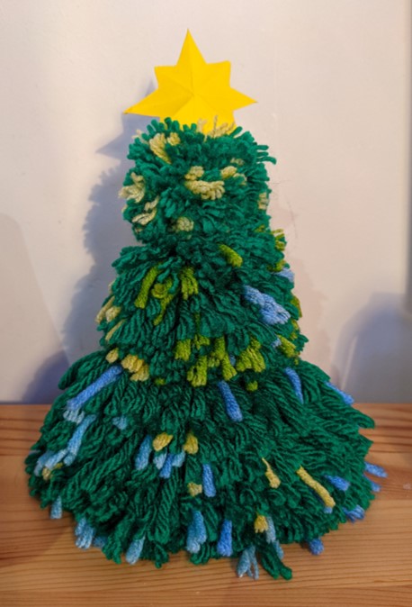 A Christmas tree made of pom-poms with a cardboard star on top.
